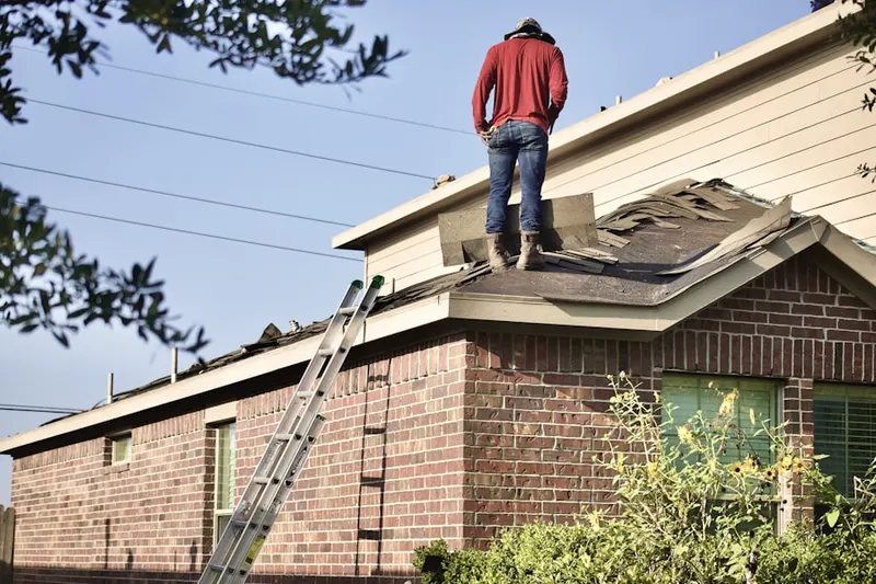 Professional roofer working on a residential roof in Columbine